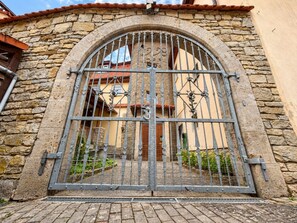 A stone building with a large arched metal gate. - Modern Apartment in a Historic Estate (Ochsenfurt)