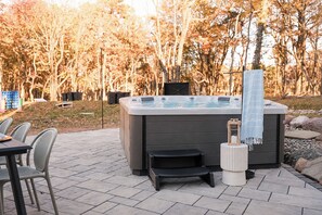 Ein Whirlpool mit einer kleinen Stufe und einem Handtuch auf einer Steinterrasse.