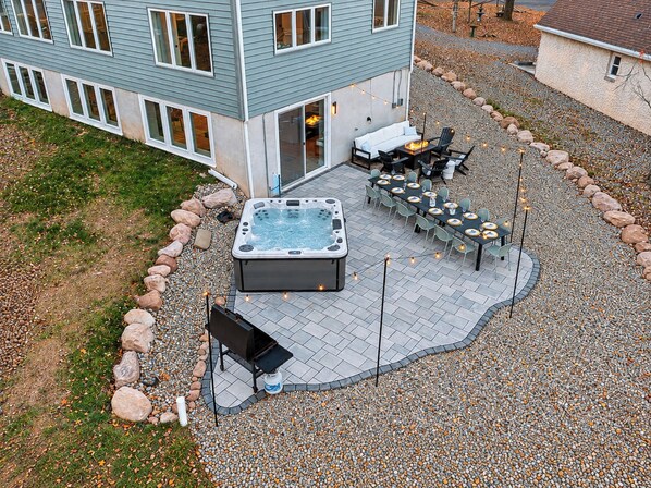 An outdoor patio with a hot tub, seating area, and a barbecue grill. - NEW Luxe 6BR | Speakeasy, Cinema, Hidden Playroom (Albrightsville)