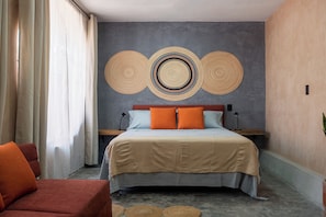 Une chambre d’hôtel comprenant un lit, deux tables de chevet, une chaise et un grand élément décoratif mural.