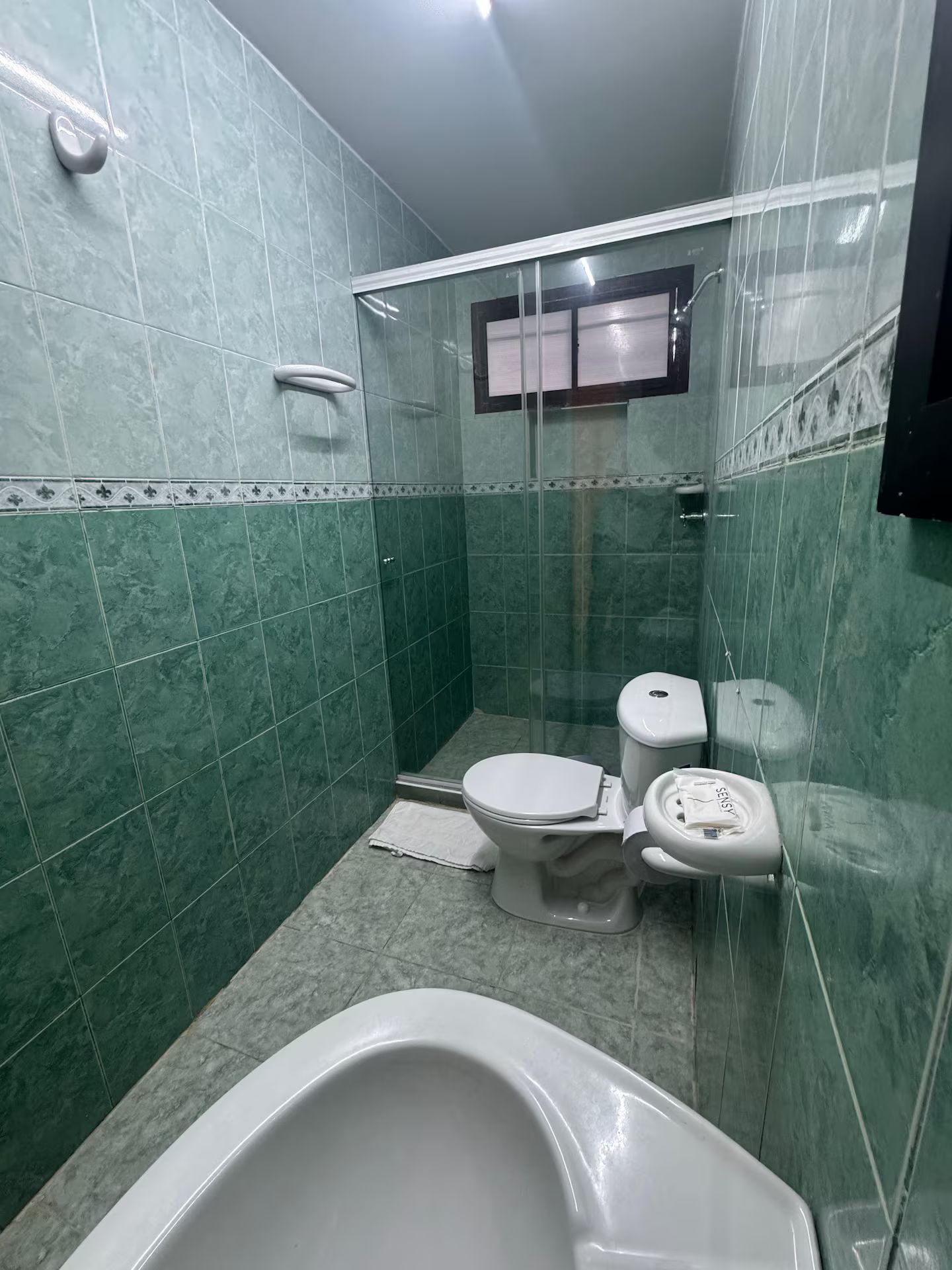 Een badkamer met een bad, twee toiletten en een douchecabine.