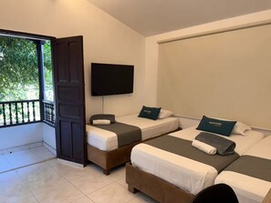 Une chambre d’hôtel avec deux lits, une télévision et un balcon.