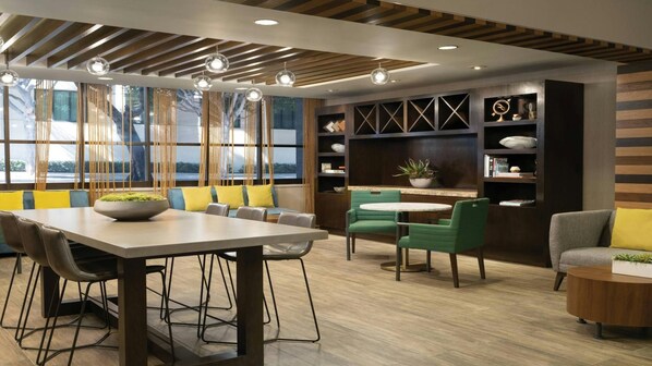 A modern interior with a dining area, seating, and a bookshelf.