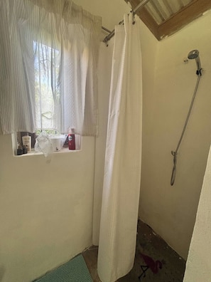 A small, enclosed shower area with a window, a showerhead, and a towel rack. - CB Tropical Paradise (Cabrera)