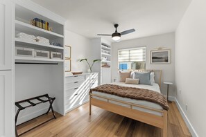 A bedroom with a bed, a wardrobe, a desk, and a window. - Lovely 1-bedroom apartment near Universal Orlando Studios! (Orlando)
