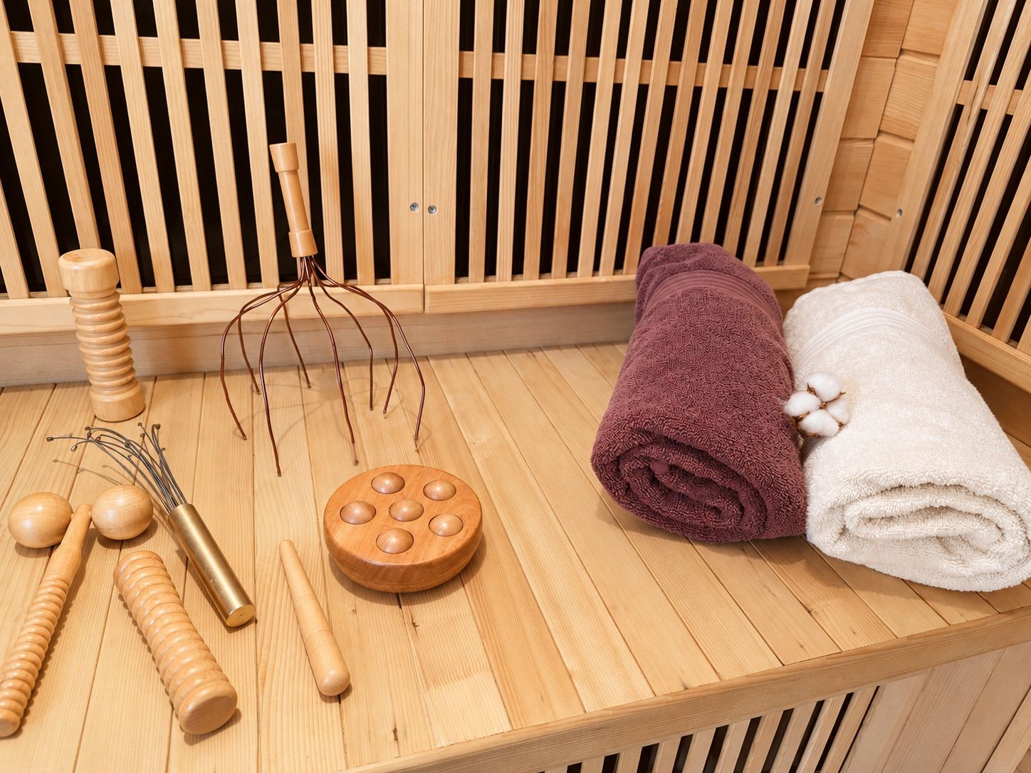 A wooden massage table with towels and massage tools.