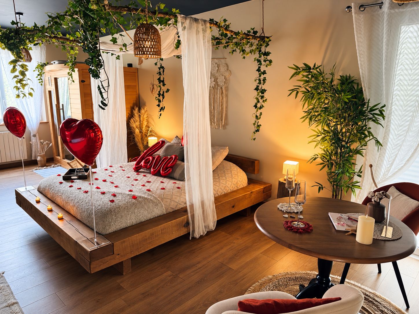 A bedroom with a bed, bedside table, and a round table with candles.