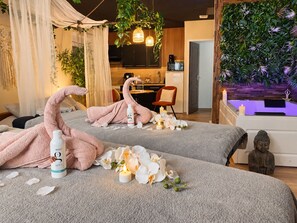 Ein Wellnessraum mit Bett, Statue und kleiner Buddha-Figur.