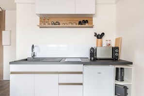 Una cocina moderna con lavavajillas incorporado, cafetera y tostadora.