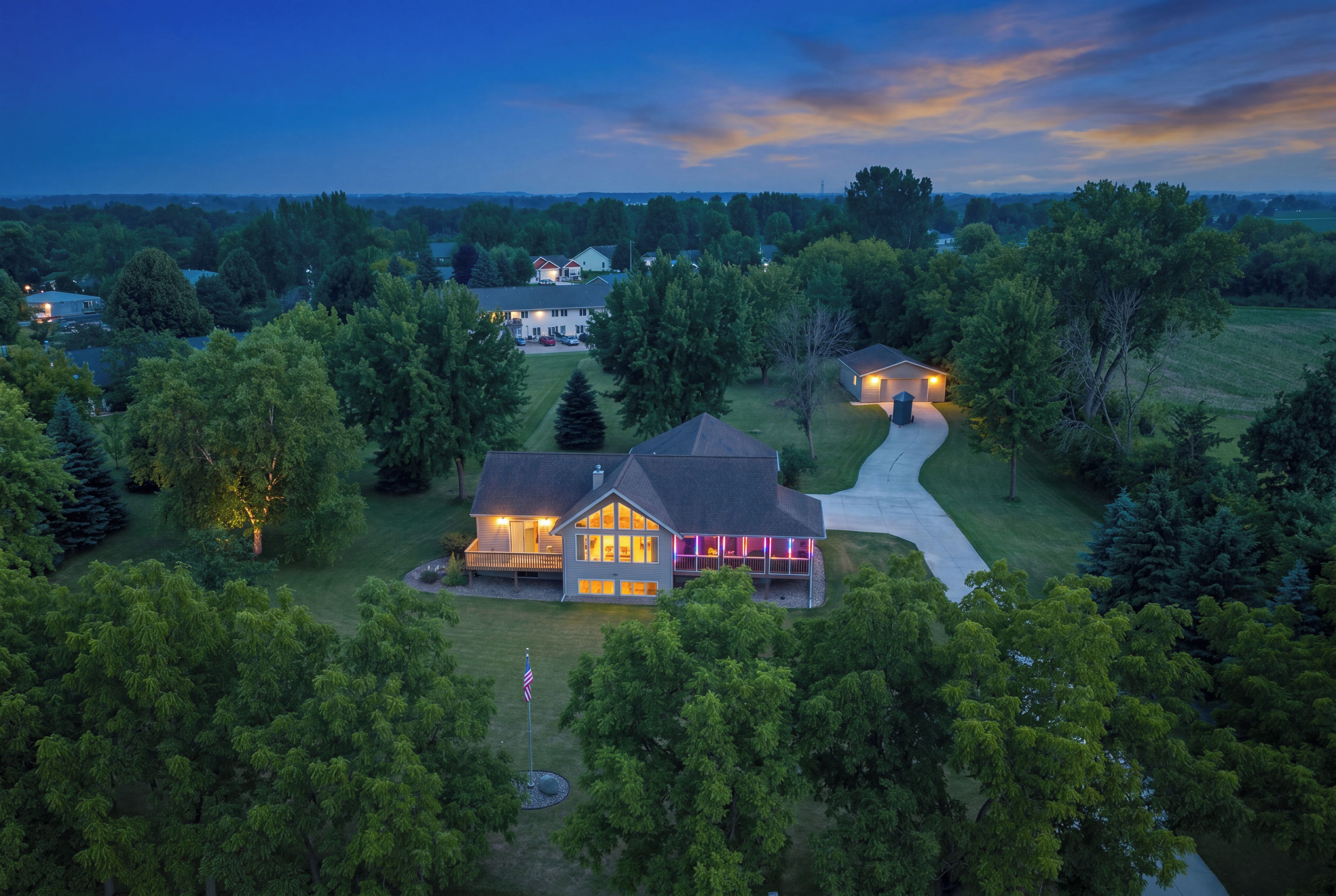 A large house with a covered porch and a driveway leading to a garage.