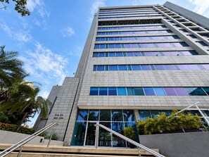 A tall building with a modern architectural design, featuring a series of windows and a visible entrance with a glass door. - New Listing (Barranquilla)