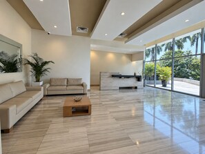 A spacious living area with a sofa, coffee table, and a reception desk. - New Listing (Barranquilla)
