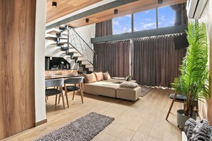 Een modern interieur met een trap, een eethoek en een zithoek.
