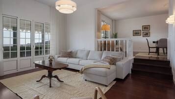 A living room with a sofa, coffee table, and a staircase leading to another level.