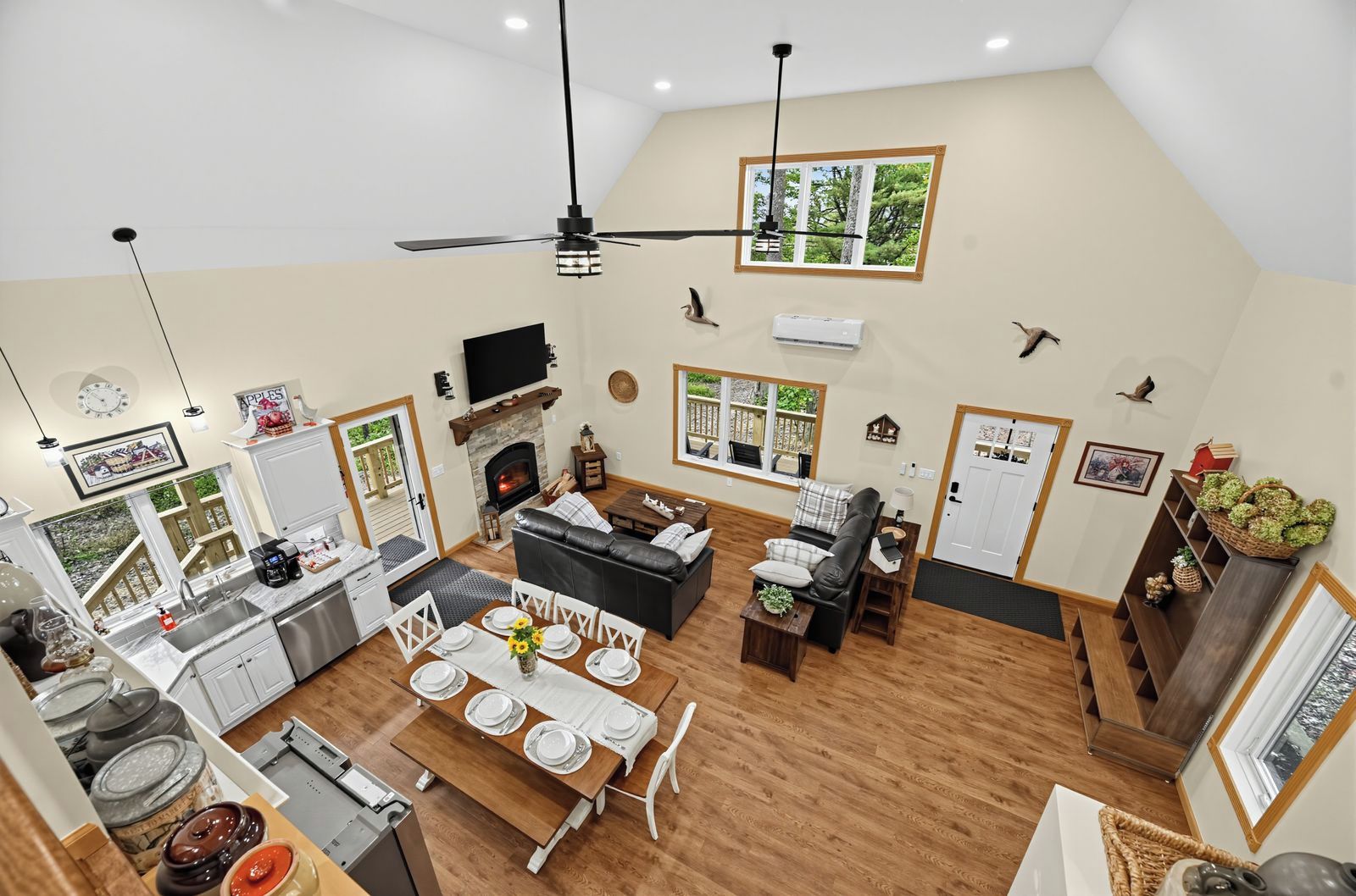 Uma sala de estar ampla com lareira, mesa de jantar e assentos.