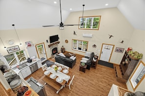 Uma sala de estar ampla com lareira, mesa de jantar e assentos.