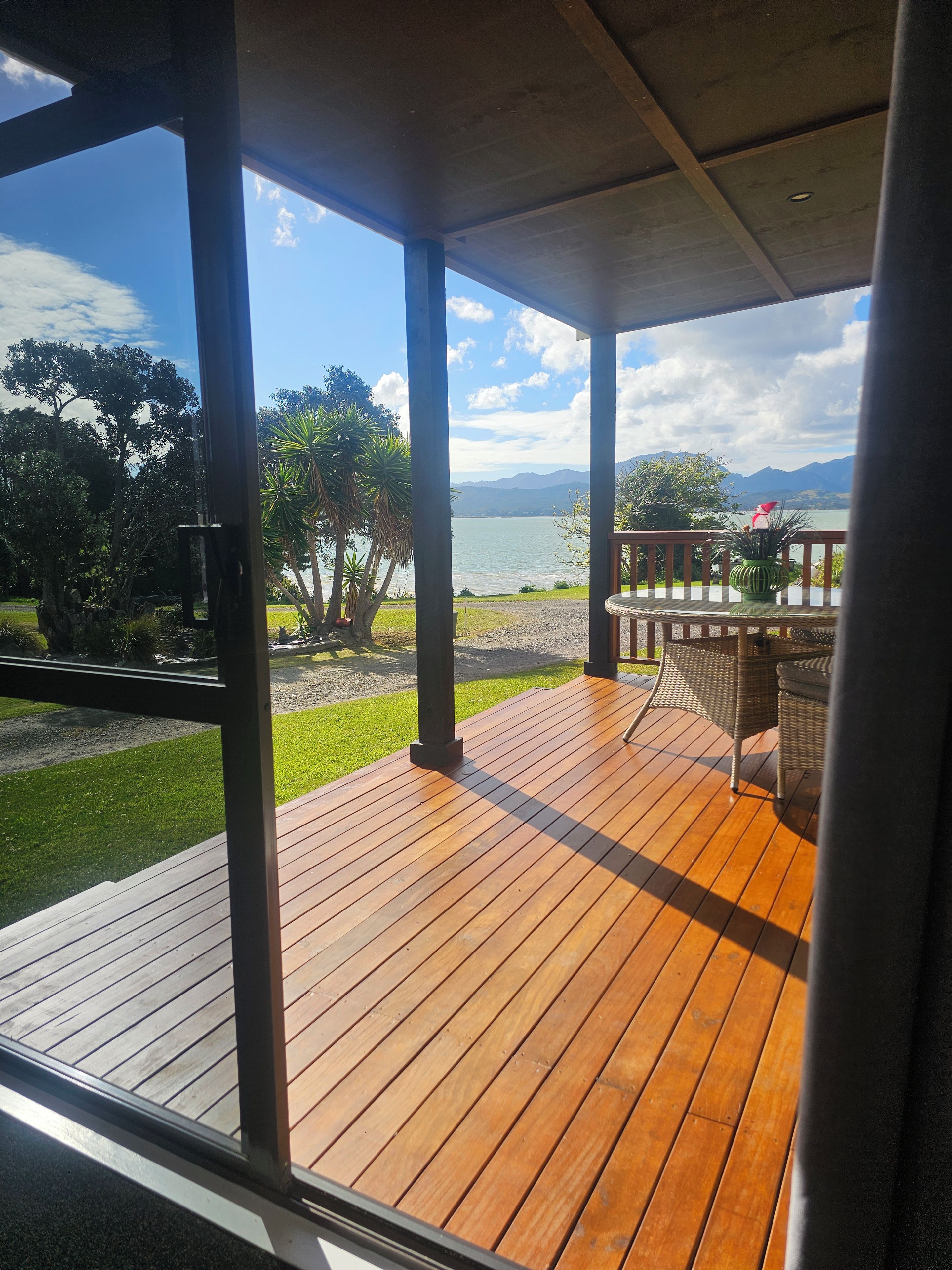 A wooden deck with a view of a lake and mountains.
