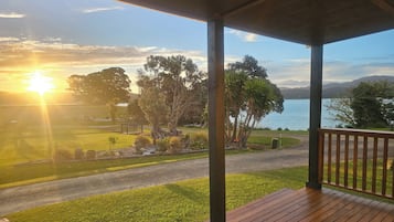 A wooden deck with a view of a lake and trees.