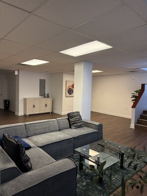 A modern interior with a sofa, glass coffee table, and a cabinet. - Family Sized Apt. — in the Heart of Hyde Park ! (Chicago)