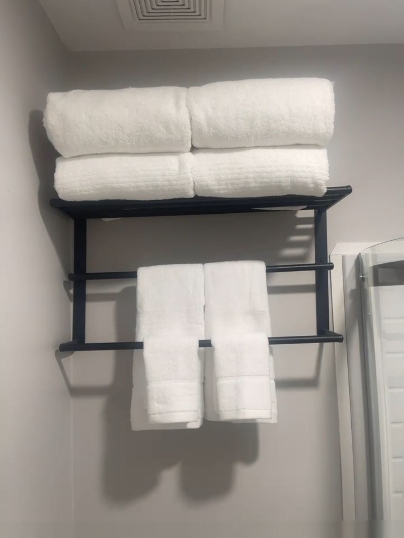 Un porte-serviettes noir avec trois serviettes blanches.