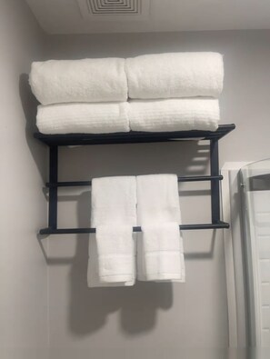 Un porte-serviettes noir avec trois serviettes blanches.