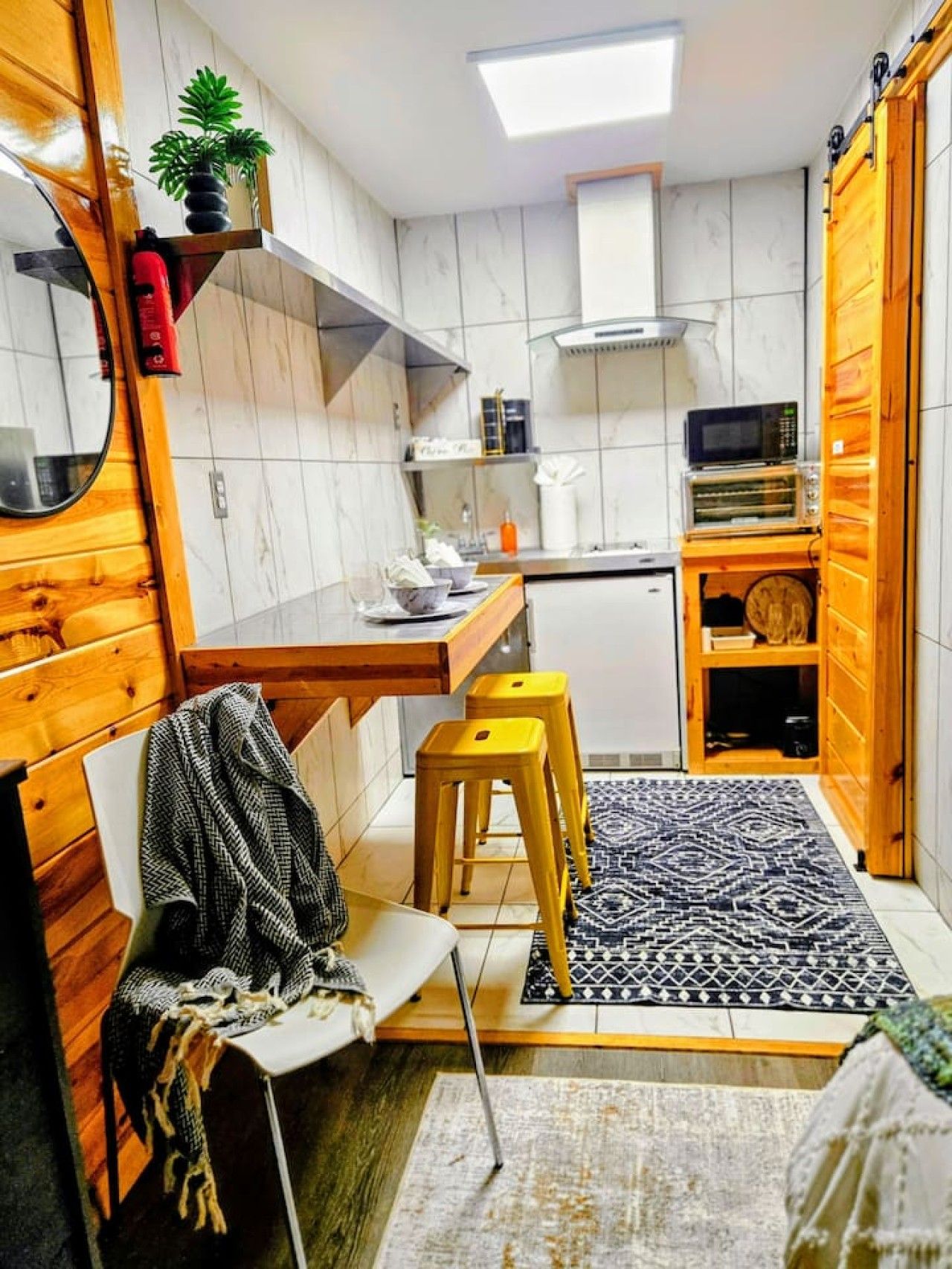 A compact kitchen with a microwave, toaster, and wooden cabinets.
