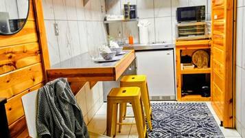 A compact kitchen with a microwave, toaster, and wooden cabinets.