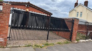 A gated property with a brick wall and a metal gate. - New Apartment - Stay 14 - Parking - TransportLinks (Coventry)