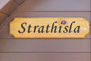 Et træskilt med navnet 'Strathisla' hængende på en væg.
