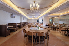 A spacious restaurant with multiple seating areas, including booths and round tables, and a central chandelier. - Vienna Hotel GZ Baiyun Airport North (guangzhou)
