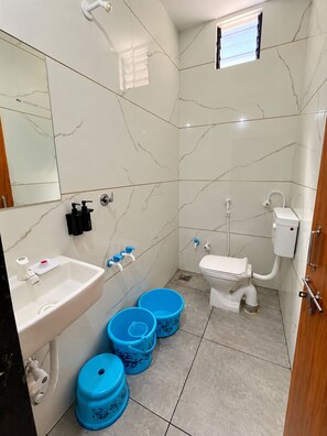 A bathroom with a sink, toilet, and two blue buckets. - Hotel Vijay Darshan, Dwarka (Dwarka)