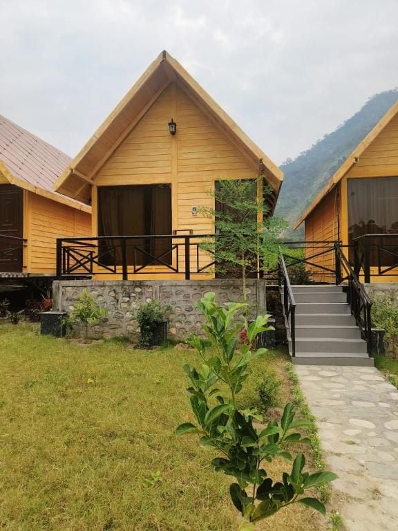 A row of wooden cabins with a stone pathway leading to a set of stairs.
