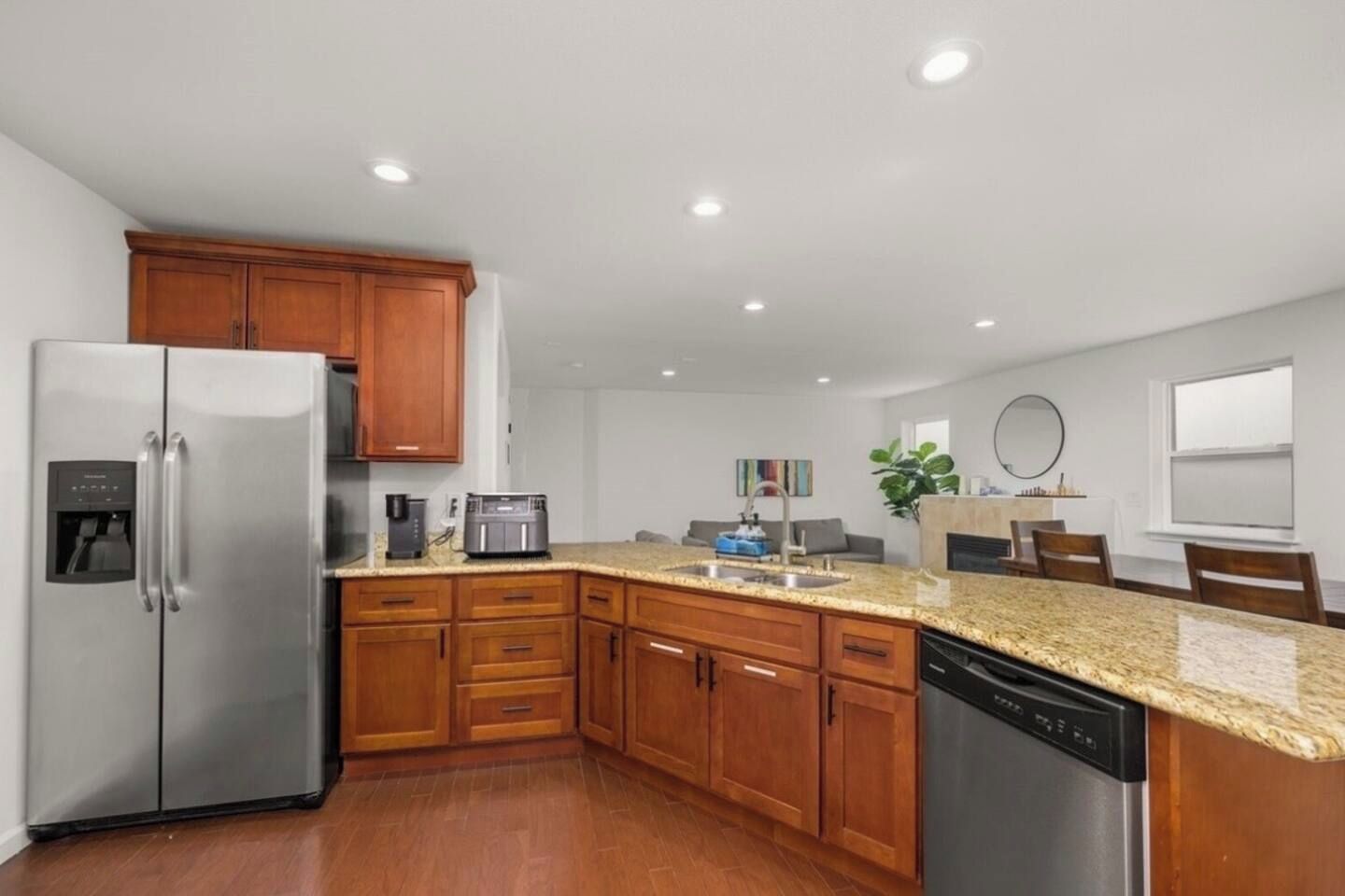 A modern kitchen with wooden cabinets, stainless steel appliances, and a granite countertop.