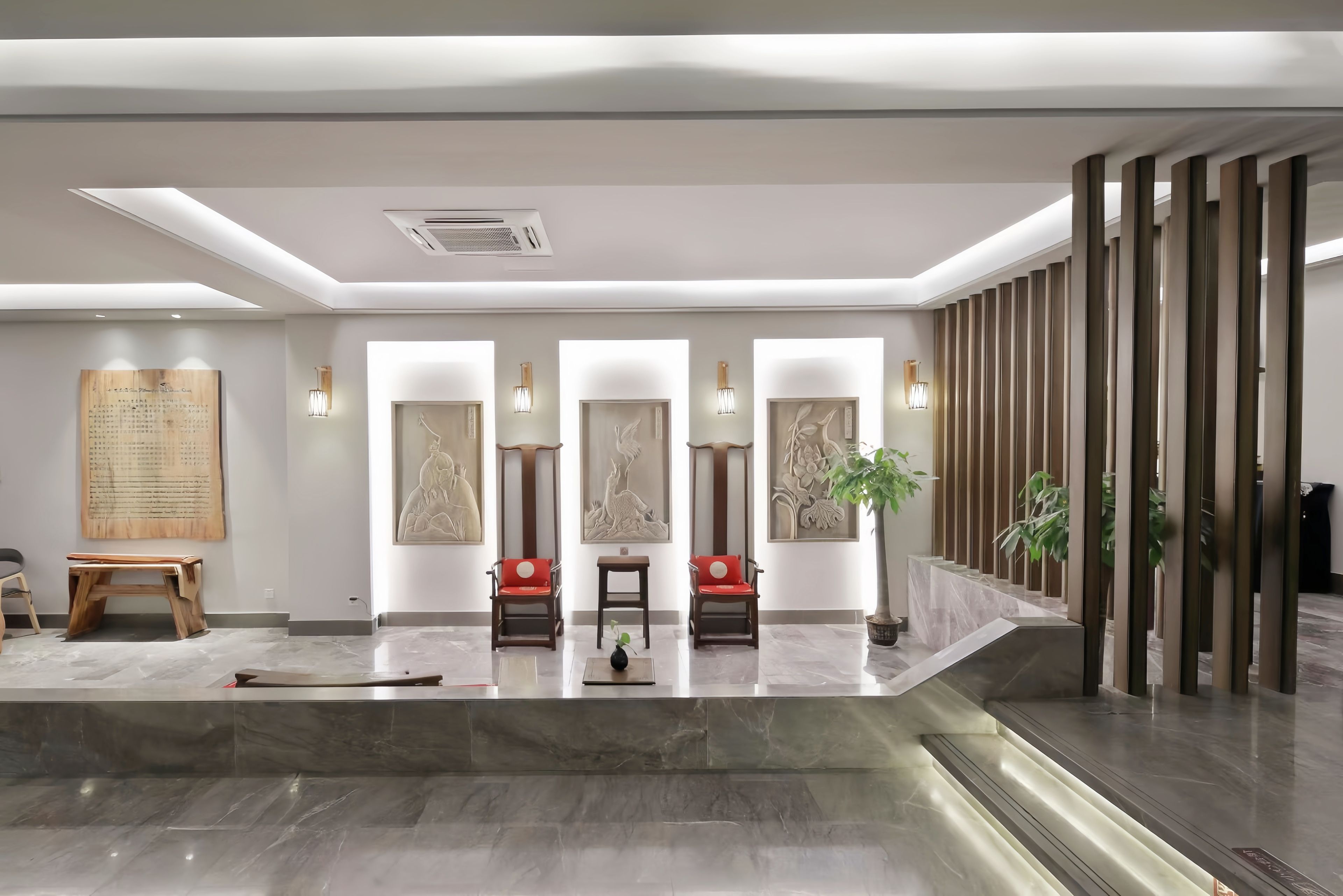 A modern lobby with a reception desk, seating area, and artwork on the walls.