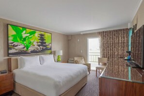Een hotelkamer met een groot bed, een bureau en een televisie.