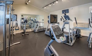 Een sportschool met loopbanden, elliptische trainers en gewichten.