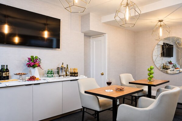Ein modernes Hotelzimmer mit Bar, Sitzgelegenheiten und einem großen Spiegel.