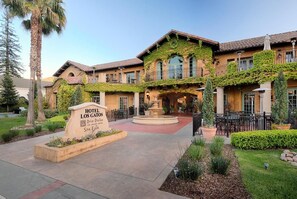 Un hotel con patio, una fuente y un letrero que indica que es el Hotel Los Gatos.