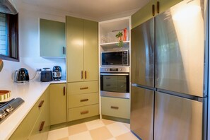 A kitchen with a microwave, oven, and stainless steel refrigerator.