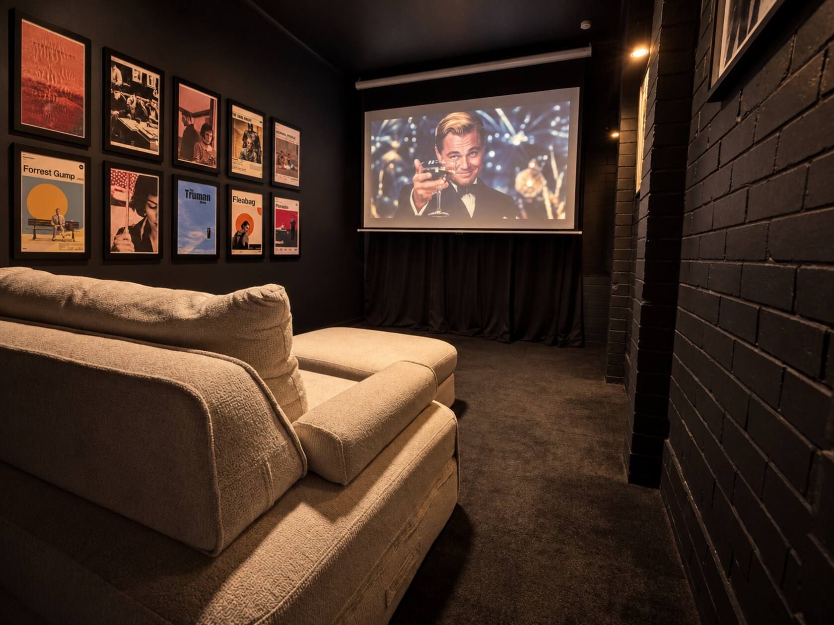 A cozy room with a large screen for viewing, a comfortable sofa, and a wall adorned with framed movie posters.