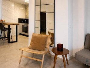 A modern living room with a wooden chair, a small round table, and a sofa. - Sea Glow by Living4Malaga (Malaga)