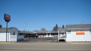 Een motel met een bord waarop 'St. Paul Lodge' staat en een parkeerplaats met een zwart voertuig.