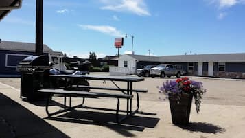 A parking lot with a picnic table, barbecue grill, and a sign for St. Paul Lodge.