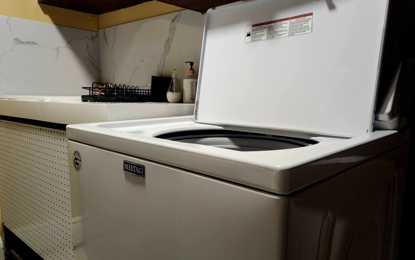 Une machine à laver Maytag dotée d’un panneau de commande et d’un compartiment pour la lessive situé sur le dessus.