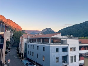 A modern building with a flat roof, multiple windows, and a parking area. - New Listing (Digne-les-Bains)
