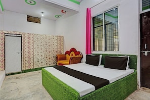 A bedroom with a bed, a window with a curtain, a door, and a patterned wall. - Hotel O Jai Bhole Guest House And Rooms (Rasulabad)
