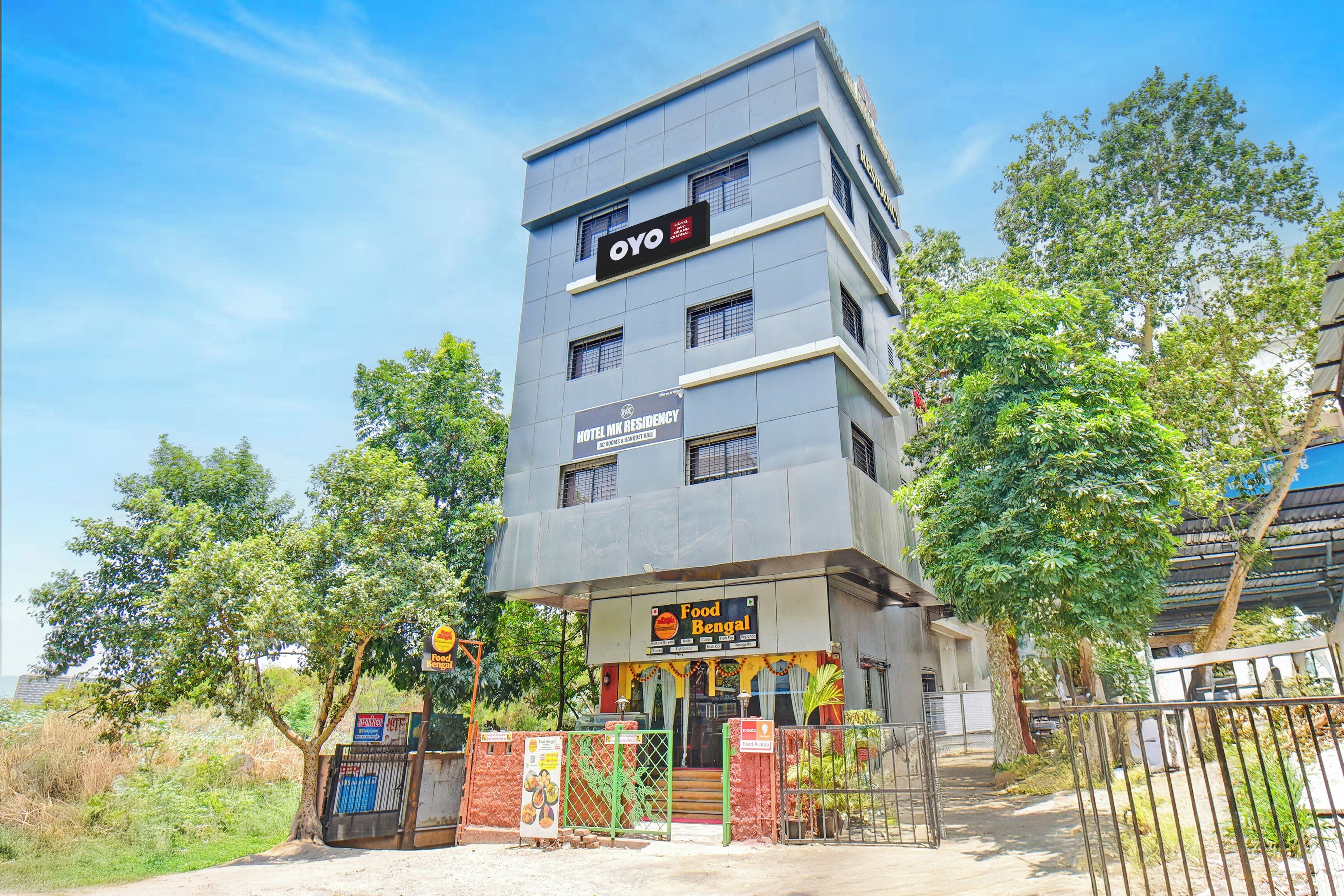 Un immeuble à plusieurs étages, sur lequel on peut lire l’enseigne « Hotel MK Residency » et qui abrite également un restaurant appelé « Food Bengal ».