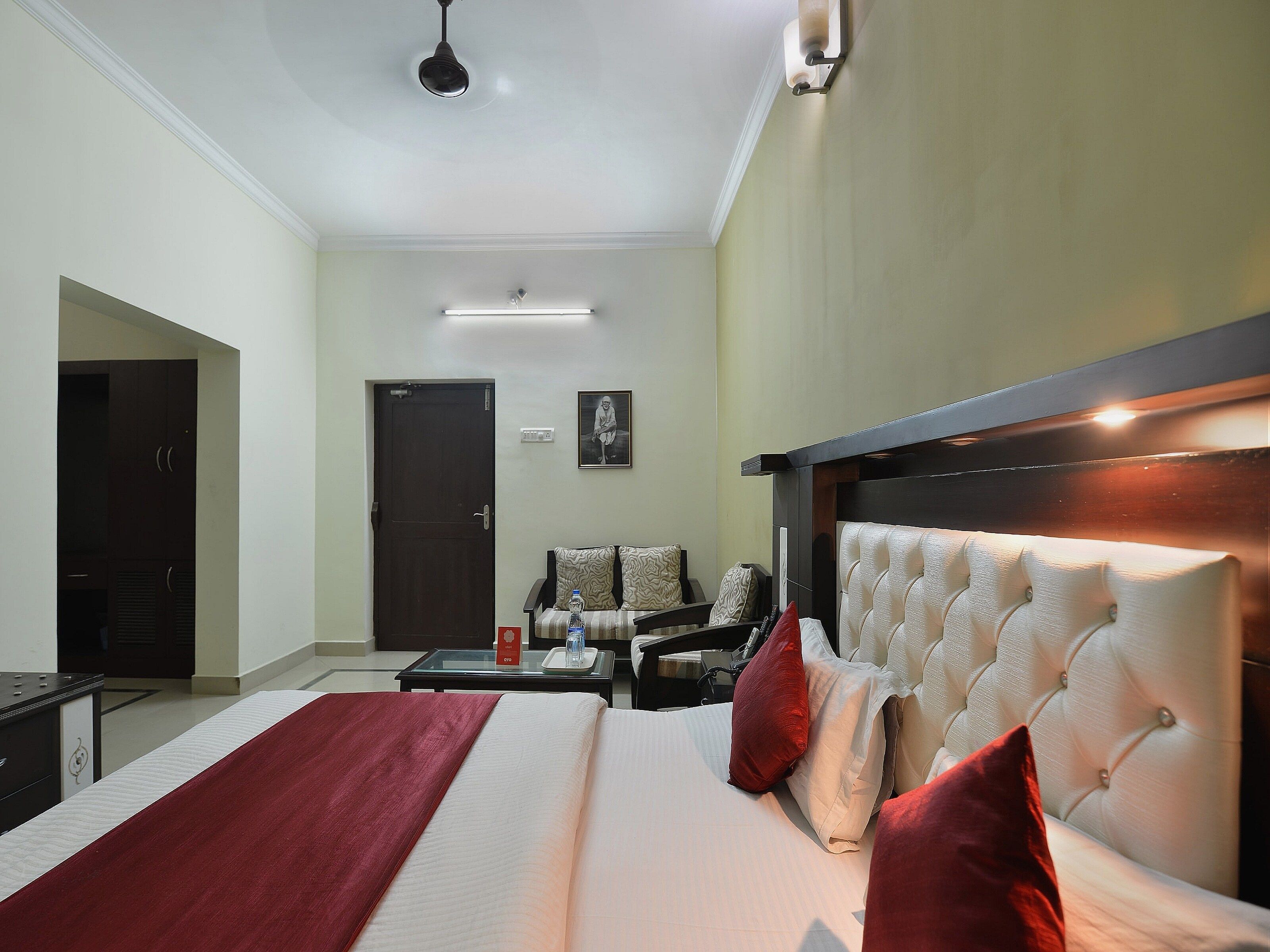 Una habitación de hotel con una cama grande, un escritorio, una silla, un sofá y una puerta.