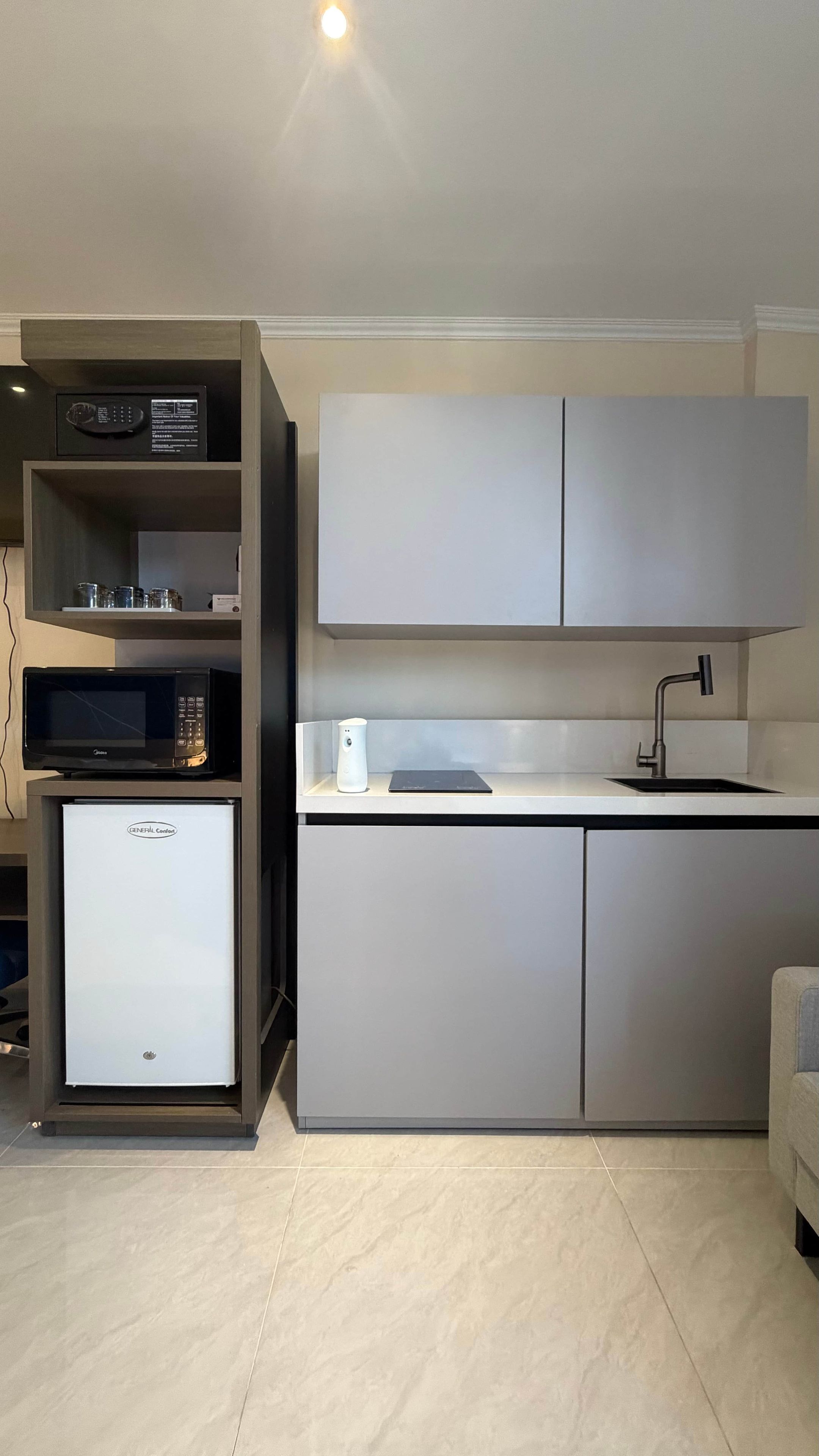 Una cocina moderna equipada con microondas, cafetera y refrigerador.
