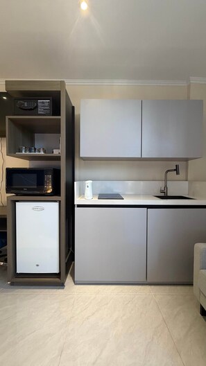 Una cocina moderna equipada con microondas, cafetera y refrigerador.